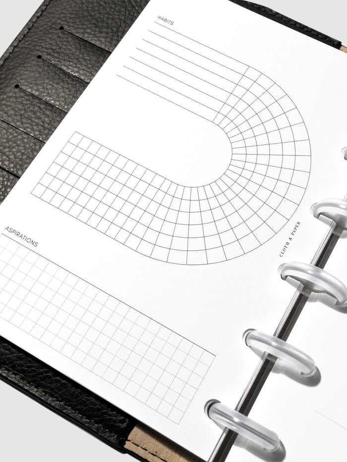 Set of inserts displayed inside a black leather planner.