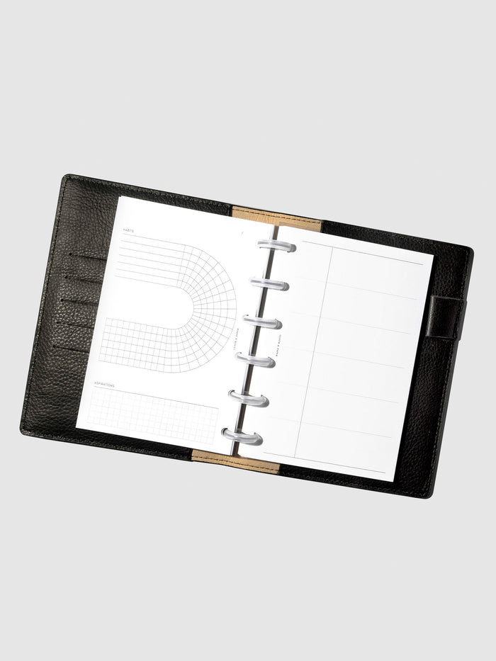 Set of inserts displayed inside a black leather planner.