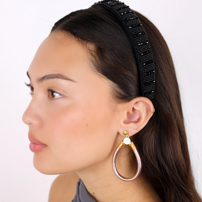 a woman with a head band and earrings